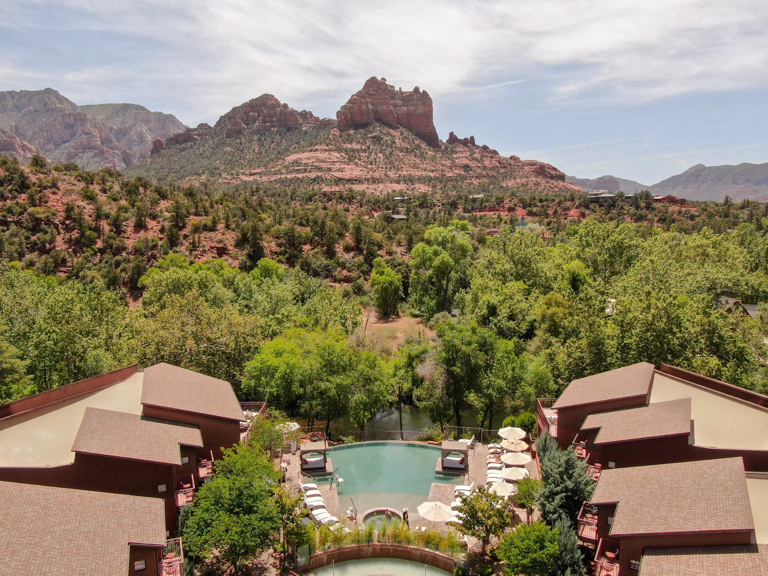 The pool and cabanas from above, with the red rocks behind
