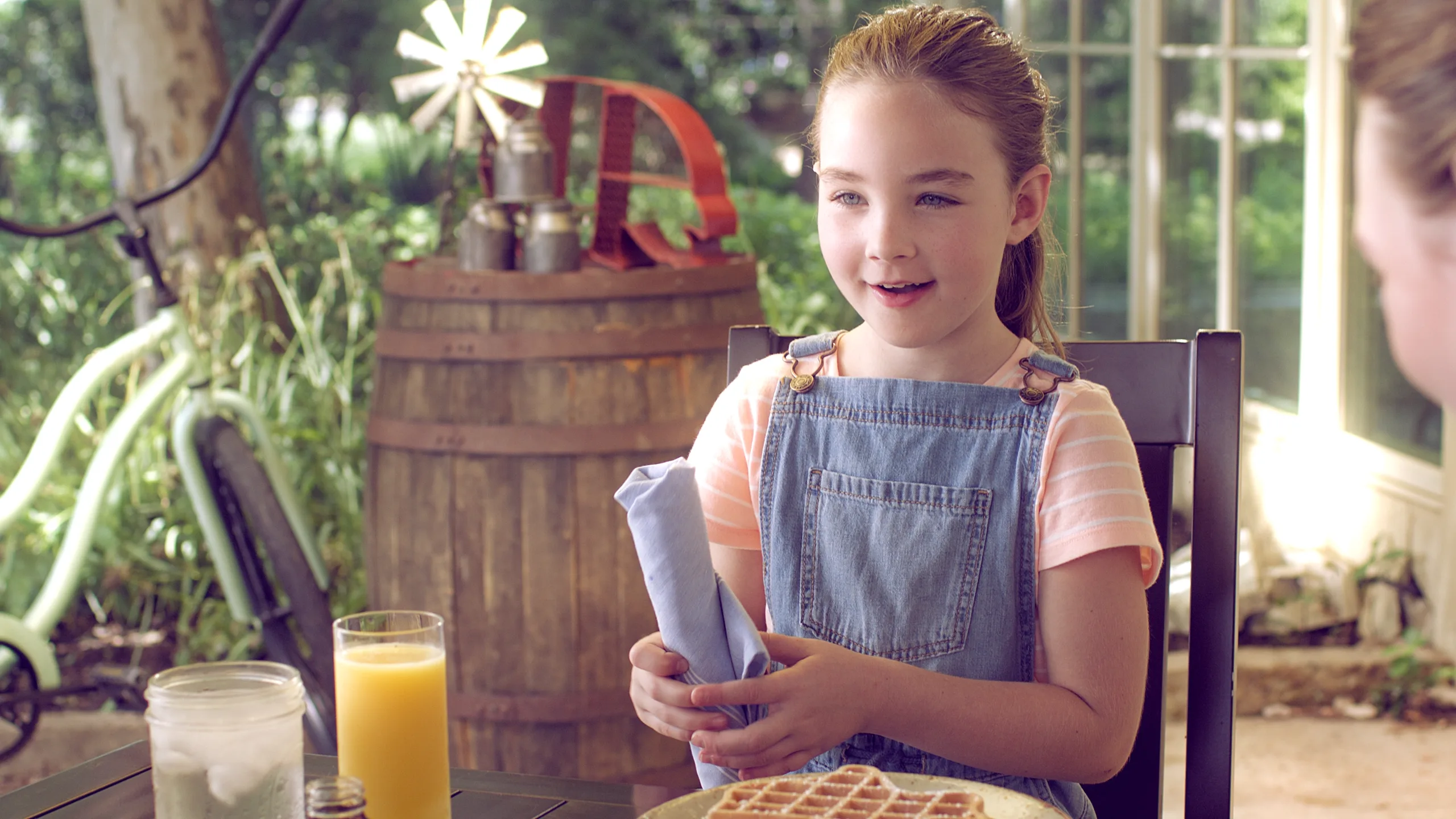 A girl at breakfast on the porch