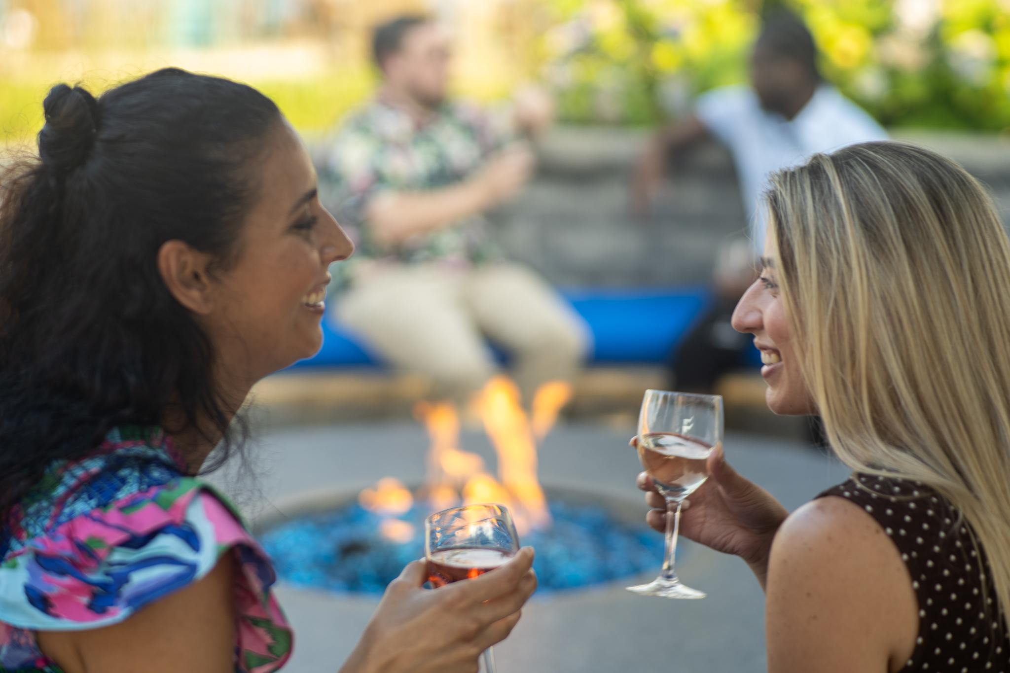 Two guests by the fire pit with wine
