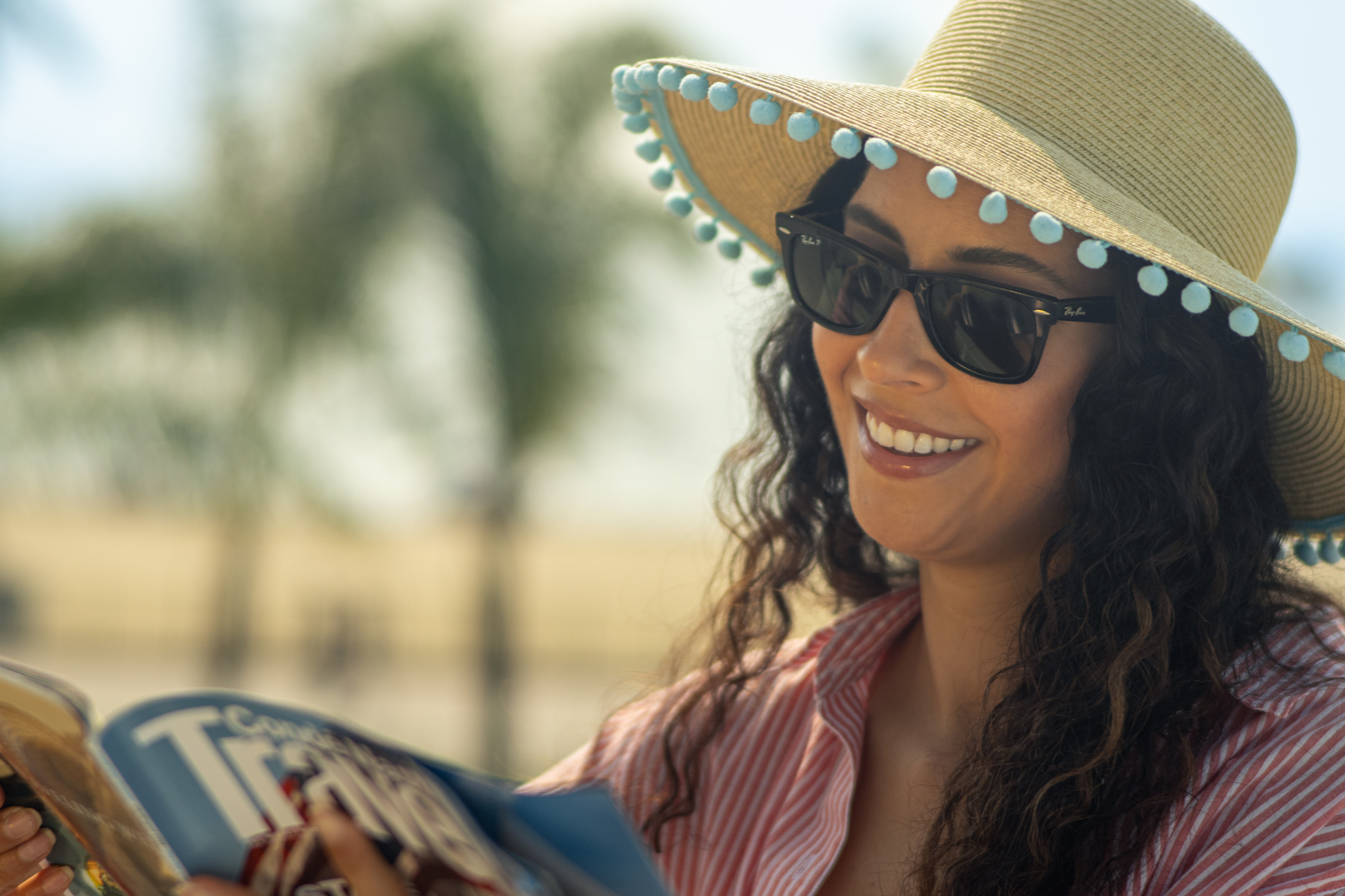 A guest smiles beneath a sun hat
