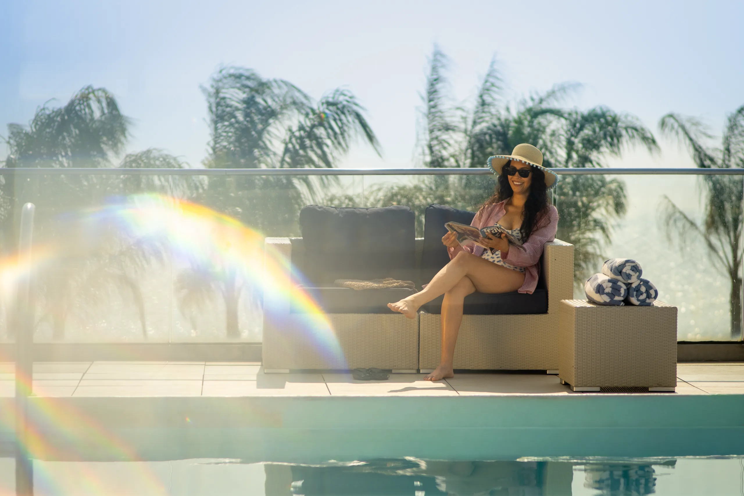 A guest reads a magazine on the pool deck