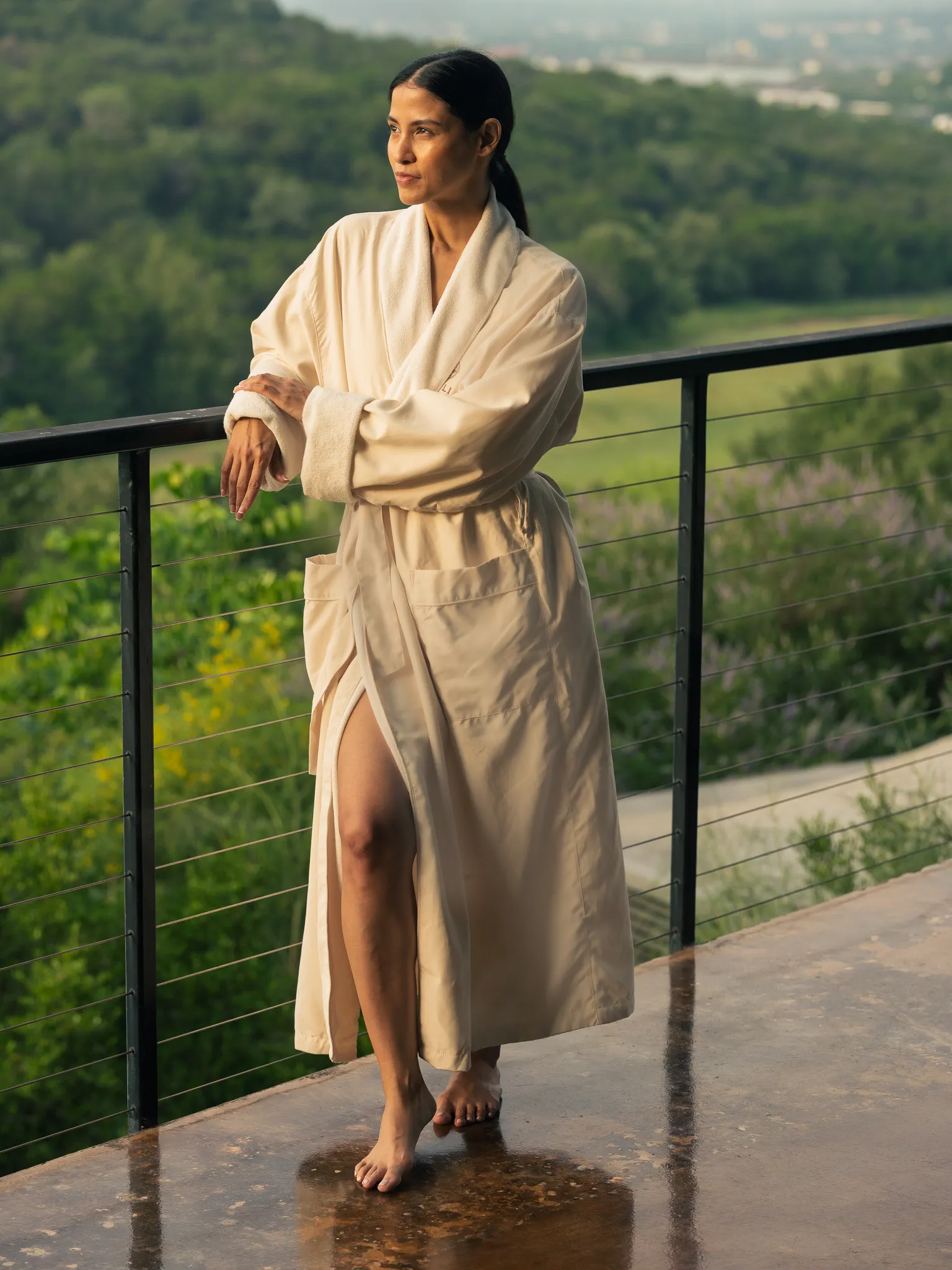 A guest in a spa robe looks out over the Hill Country