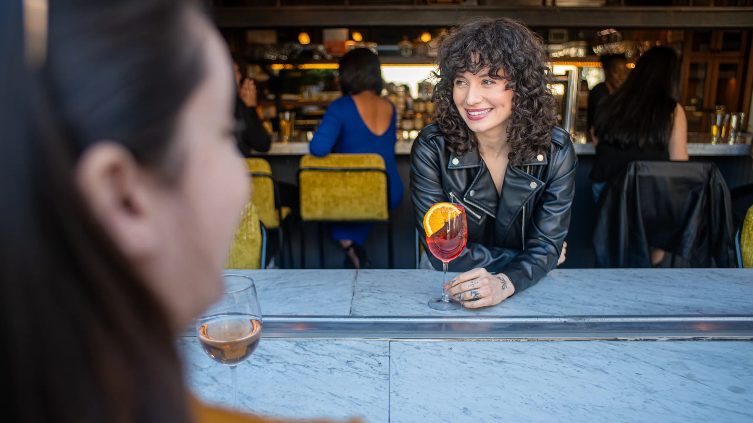A guest with a spritz at the marble bar