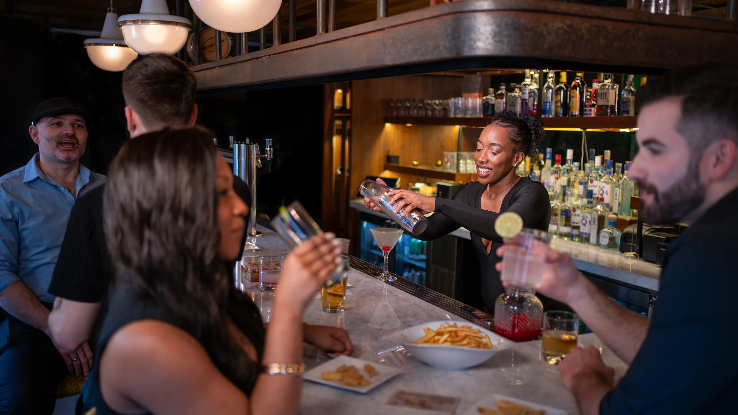 The bartender shakes a cocktail for guests
